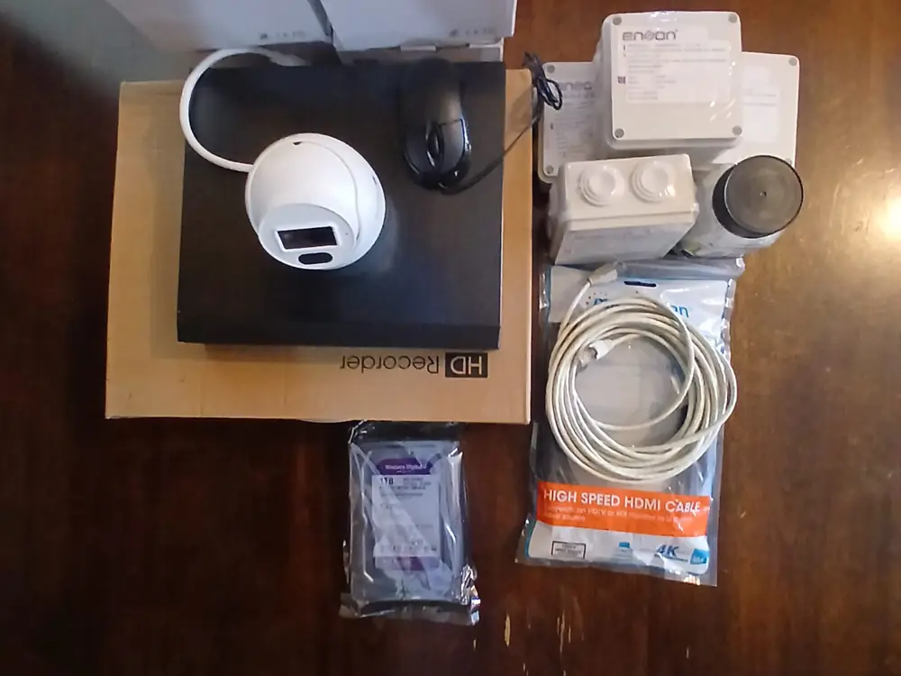Kit completo sobre una mesa: cámara, grabador, disco duro WD Purple, cajas estancas y cable HDMI